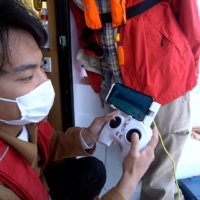 Yoshiyuki Serizawa, head of drone firm Tryworth, operates an underwater drone.  | COURTESY OF TRYWORTH
