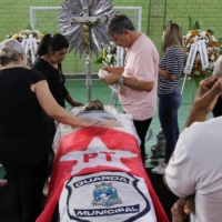 Relatives and friends of Marcelo Arruda, a supporter of Brazilian former President Luiz Inacio Lula da Silva killed by an alleged supporter of Brazilian President Bolsonaro, mourn next to his coffin in Foz do Iguacu, Brazil, on Sunday. | REUTERS