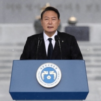 South Korean President Yoon Suk-yeol speaks during a ceremony marking Korean Memorial Day at the Seoul National cemetery on Wednesday. Yoon will suspend informal media briefings, citing rising numbers of COVID-19 infections. | POOL / VIA REUTERS