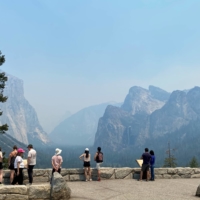 Visitors view Yosemite National Park obscured by thick smoke in the area from the wildfire burning to the south in the Mariposa Grove of Giant Sequoias in California on Saturday. | U.S. NATIONAL PARK SERVICE / VIA REUTERS 