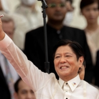 Ferdinand \"Bongbong\" Marcos Jr. waves to the audience after being sworn in as president of the Philippines in Manila on June 30. | REUTERS 