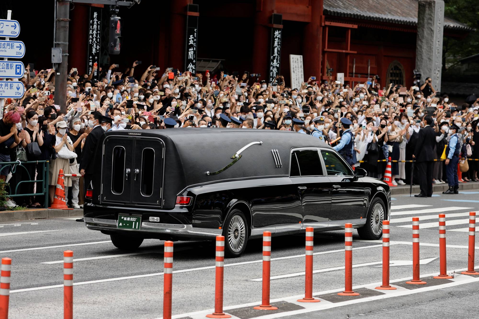 A vehicle carrying the body of the former Prime Minister Shinzo Abe, who was shot while campaigning in an Upper House election, leaves after his funeral at Zojoji temple in Tokyo on Tuesday. | REUTERS