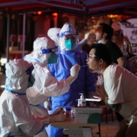 A man gets tested for COVID-19 in Shanghai on Tuesday following an outbreak. | REUTERS