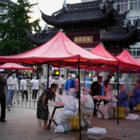 People line up to get tested for COVID-19 in Shanghai on Tuesday following an outbreak. | REUTERS