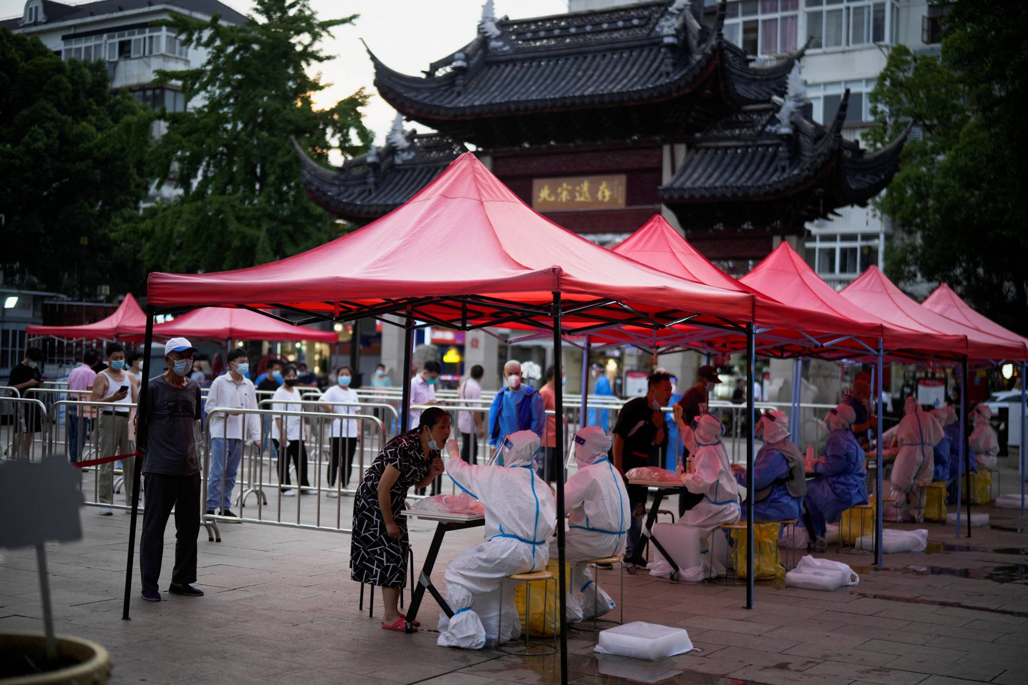 People line up to get tested for COVID-19 in Shanghai on Tuesday following an outbreak. | REUTERS