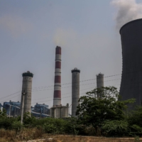 Steam billows from a cooling tower and chimneys at the coal-fired NTPC Simhadri thermal power plant in the outskirts of Visakhapatnam, Andhra Pradesh, India, in March. | BLOOMBERG