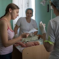 Marina Tupata, 26, stands next to her 6-day-old baby, Sofia, inside Pokrovsk maternity hospital in the Donetsk region of eastern Ukraine on June 29. | REUTERS