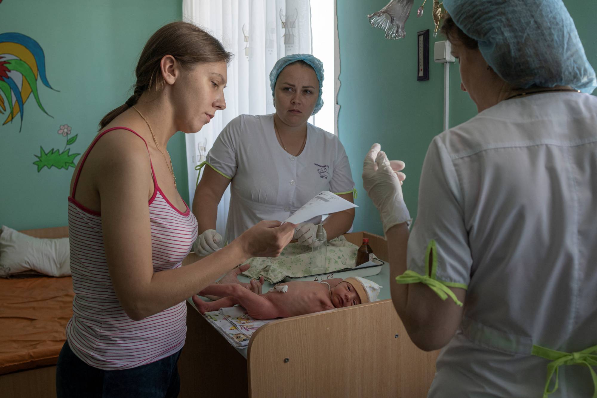 Marina Tupata, 26, stands next to her 6-day-old baby, Sofia, inside Pokrovsk maternity hospital in the Donetsk region of eastern Ukraine on June 29. | REUTERS