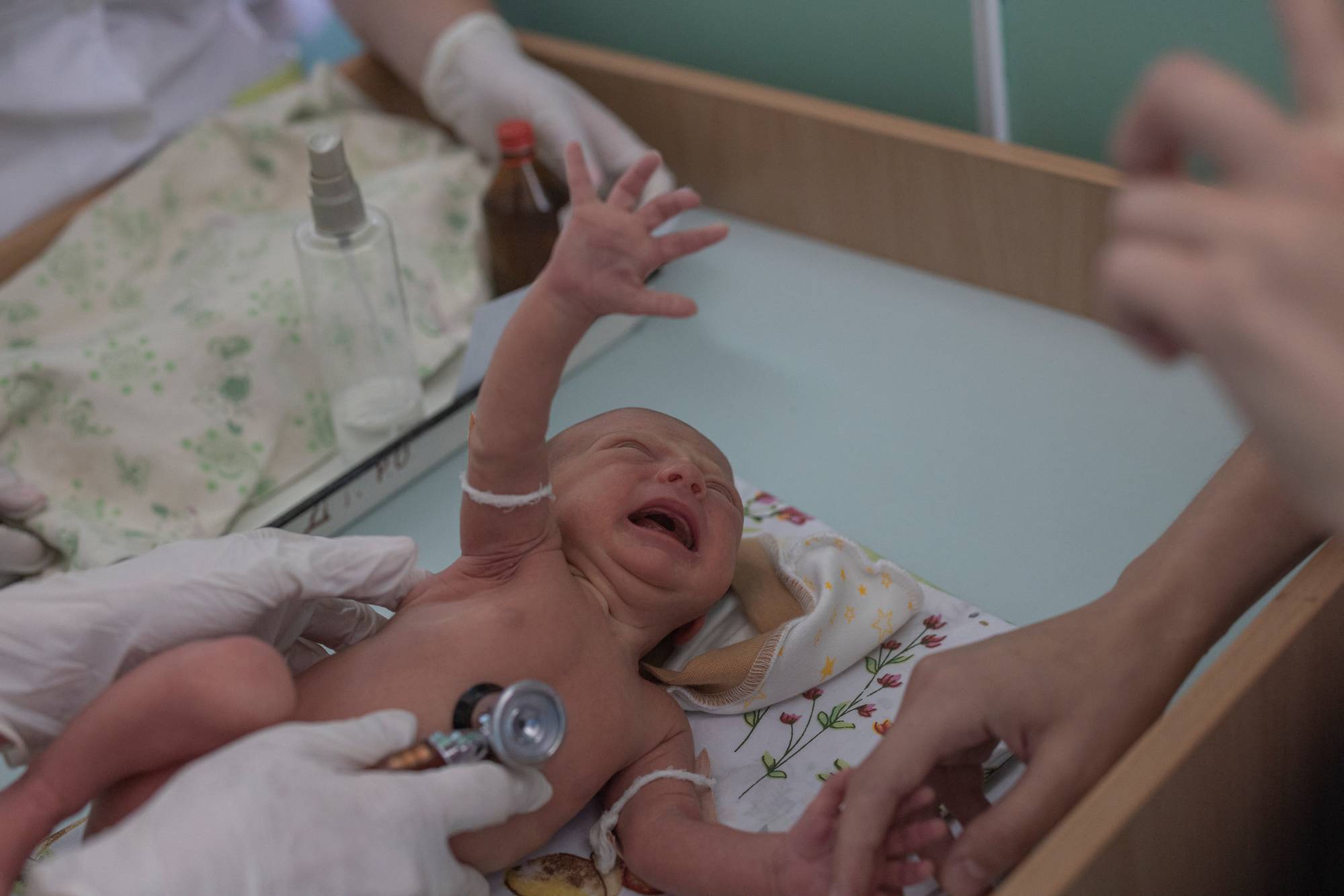 Marina Tupata watches as her baby Sofia is examined inside Pokrovsk maternity hospital on June 29. The Pokrovsk facility now serves the remaining population of the Ukraine-controlled Donetsk region, about 340,000 people, according to the regional governor. | Reuters