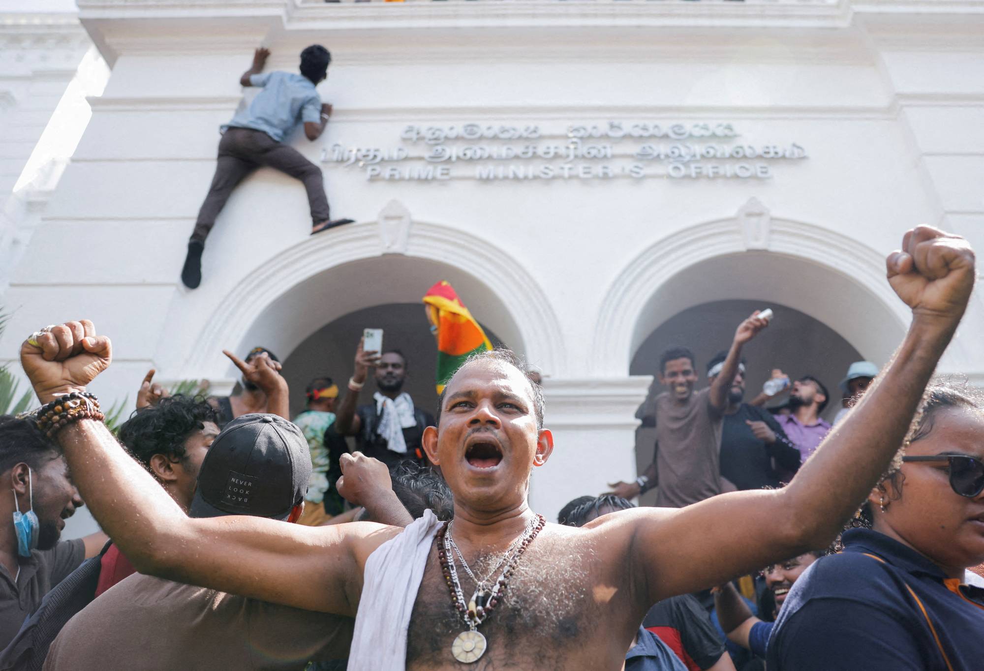 Demonstrators celebrate after they enter into the Sri Lankan prime minister’s office in Colombo on Wednesday during a protest demanding for his resignation and after President Gotabaya Rajapaksa fled amid the country’s economic crisis.  | REUTERS