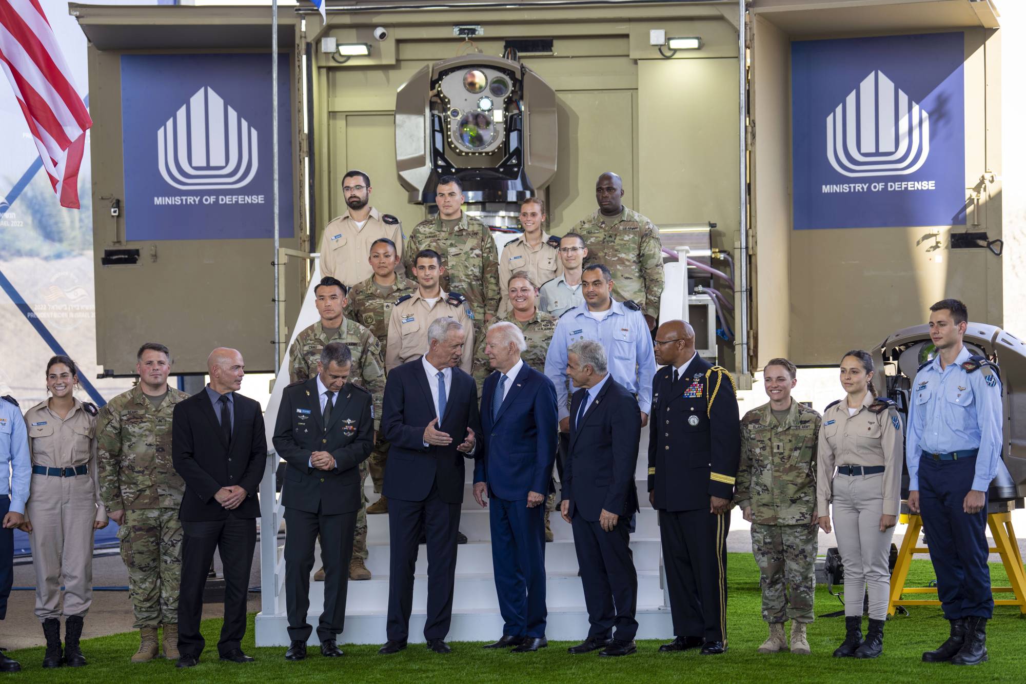U.S. President Joe Biden (center) is flanked by Israeli Defense Minister Benny Gantz (left) and Prime Minister Yair Lapid as he views a prototype of Iron Beam, Israel's new laser defense system, at Ben Gurion International Airport near Jerusalem on Wednesday. | Doug Mills / The New York Times