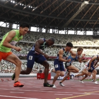 Sprinters compete in the men\'s 100-meter race during a Tokyo 2020 test event at National Stadium in May 2021. | REUTERS