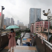 A woman is recorded on surveillance cameras as she walks on a pedestrian bridge near Caopu in Shenzhen. | REUTERS