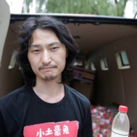 Chinese performance artist Nut Brother holds bottled polluted groundwater from Shaanxi province as part of a roaming exhibition in Beijing in 2018.  | REUTERS