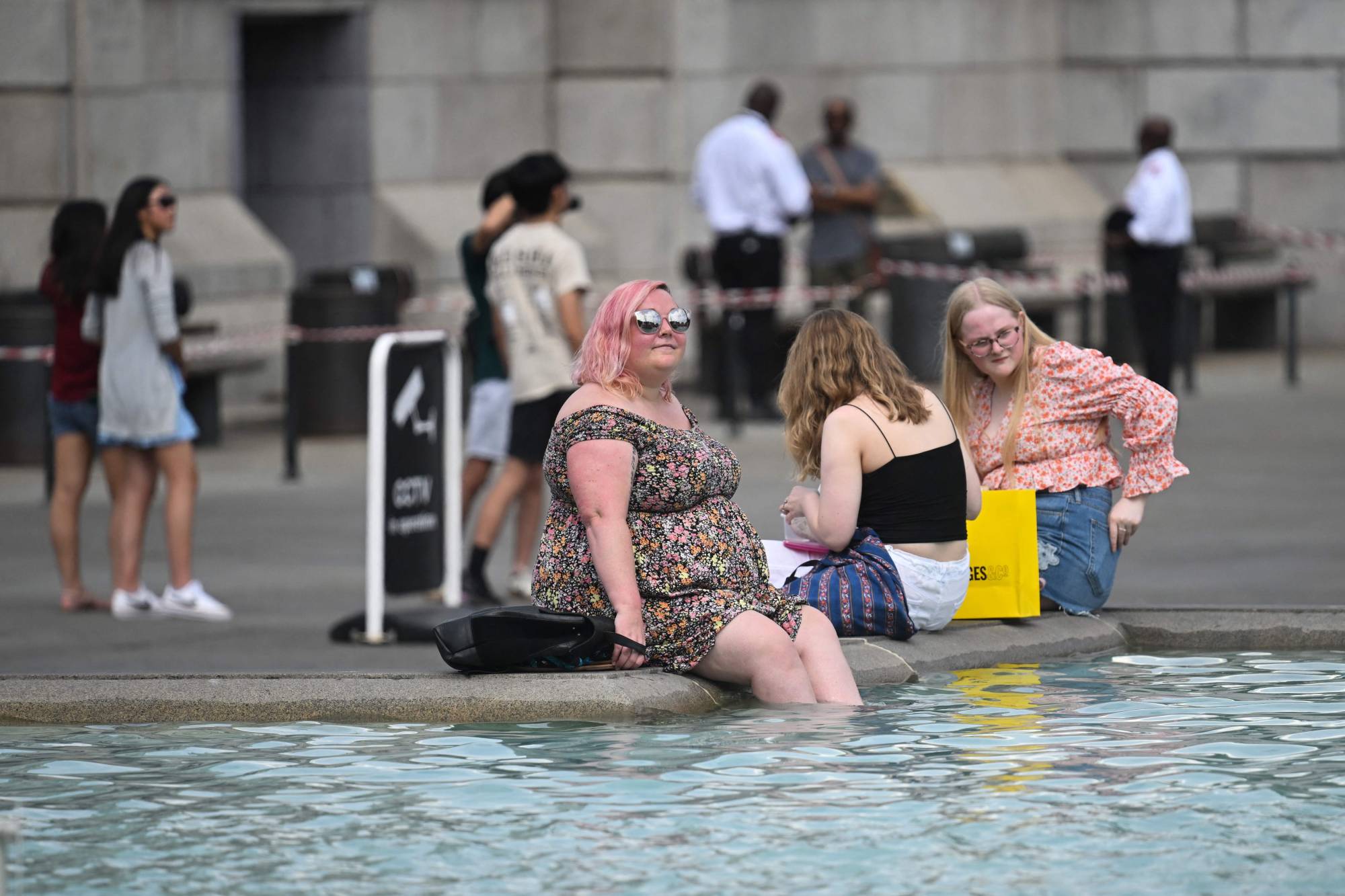 People cool off in the Trafalgar Square fountain in central London on Wednesday.  | AFP-JIJI