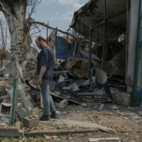 A resident walks by the entrance of a destroyed bazaar hit by shelling Saturday in Bakhmut, Ukraine, on Saturday, where Russian troops are trying to advance. Bakhmut has been battered by shelling this week, as Russia seeks to take the remaining Ukrainian-held areas of Donetsk province.  | MAURICIO LIMA / THE NEW YORK TIMES