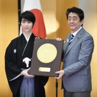 Hanyu receives the People\'s Honor Award from then-Prime Minister Shinzo Abe during a ceremony in Tokyo in July 2018. | KYODO