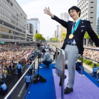 Hanyu waves to people in Sendai in April 2018 during a parade to celebrate his second Olympic gold medal, which he won in the men\'s figure skating competition at the 2018 Pyeongchang Winter Olympics. | KYODO