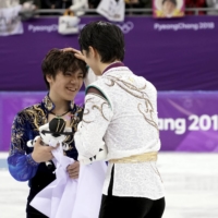 Hanyu (right) and Shoma Uno celebrate after winning gold and silver in the men’s singles competition at the 2018 Winter Olympics in Pyeongchang, South Korea. | CHANG W. LEE / THE NEW YORK TIMES