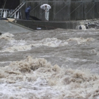Water levels rise sharply in the Kusu river in Hita, Oita Prefecture, as record rainfall hits the city on Tuesday. | KYODO