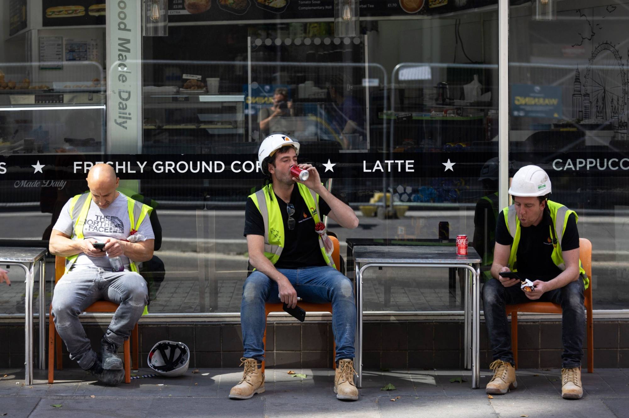 Workmen take a break outside a cafe during a heat wave in London. | Bloomberg
