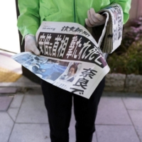 A vendor distributes copies of a special edition of the Yomiuri Shimbun newspaper with a report about the death of former Japanese Prime Minister Shinzo Abe.  | BLOOMBERG