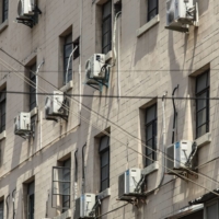 Air conditioner units on a building in Shanghai. China is one of many places on the planet experiencing unprecedented heat. Over the past month, scorching temperatures have affected 900 million people across the country, killing several. | BLOOMBERG