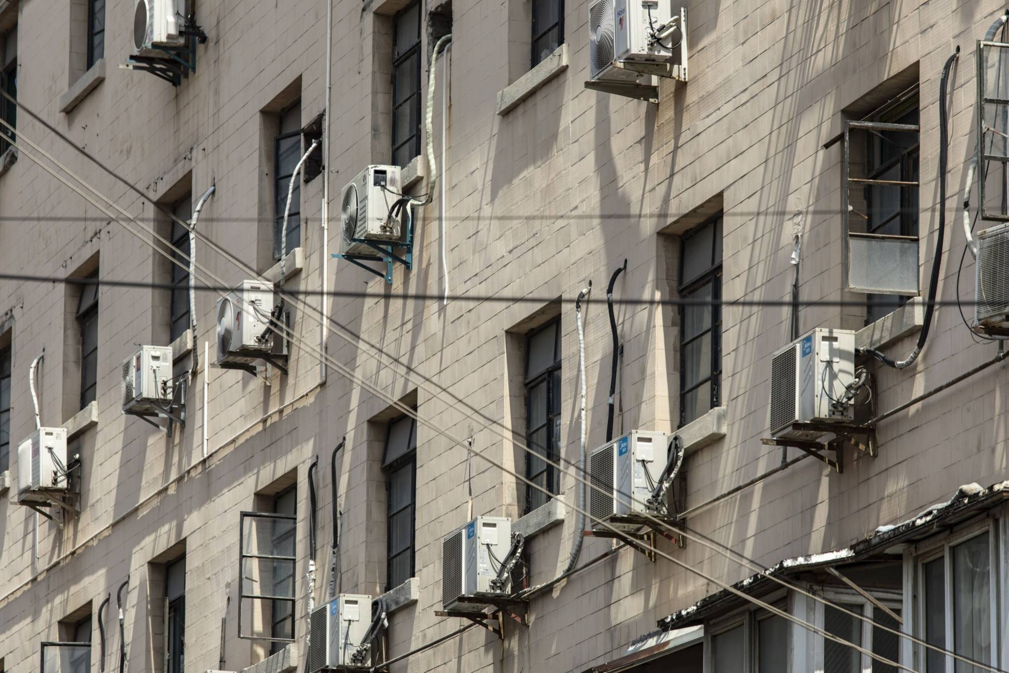 Air conditioner units on a building in Shanghai. China is one of many places on the planet experiencing unprecedented heat. Over the past month, scorching temperatures have affected 900 million people across the country, killing several. | BLOOMBERG