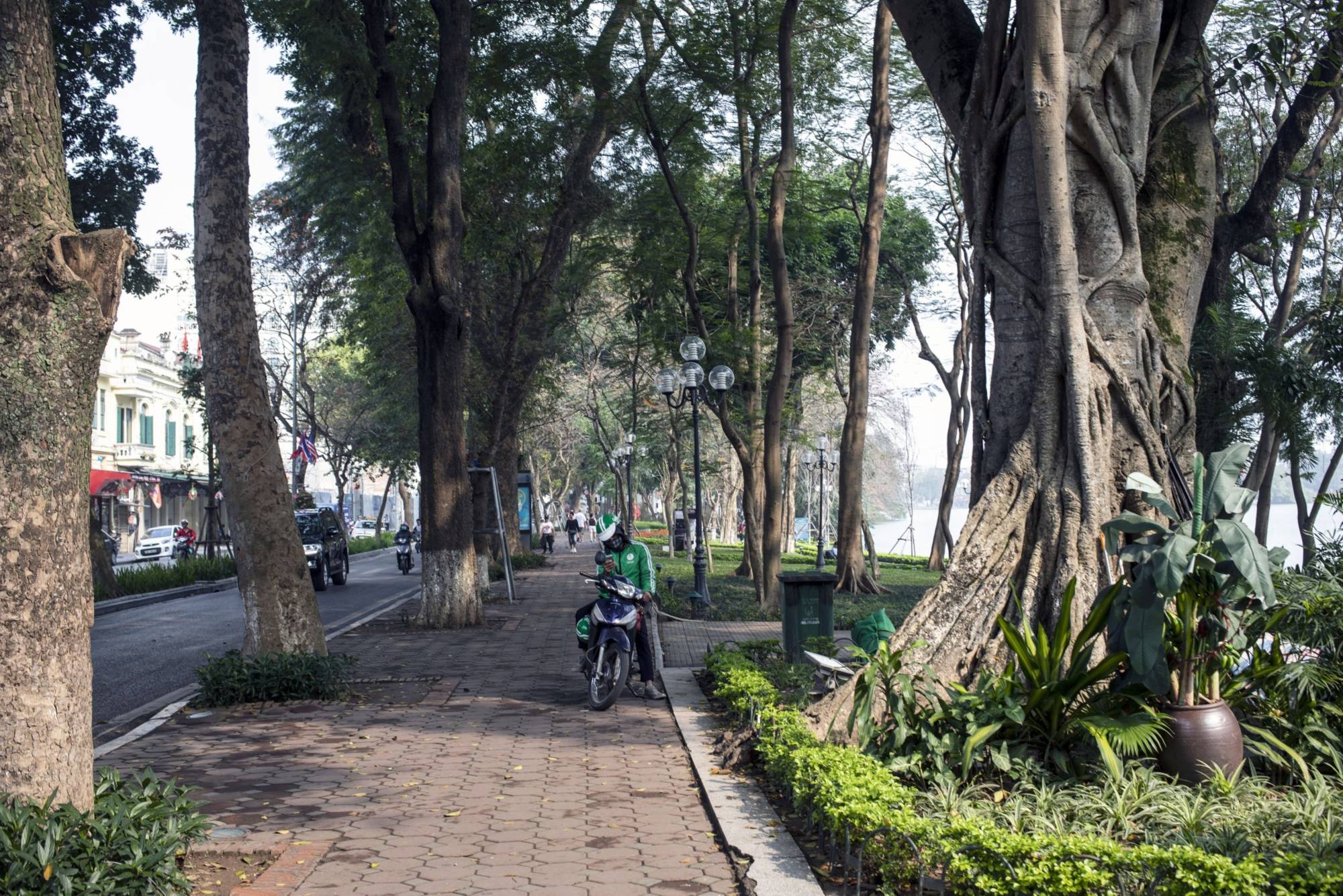 A Grab bike driver uses a smartphone near Hoan Kiem Lake in Hanoi in March 2019. | Bloomberg