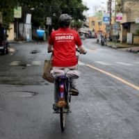 A Zomato delivery worker rides her bicycle along a road in Kolkata in July 2021. Demand for gig work has surged in recent years with the growth in e-commerce and the so-called \"platformization\" of work, with advocates saying it offers both sides greater freedom and flexibility. | REUTERS