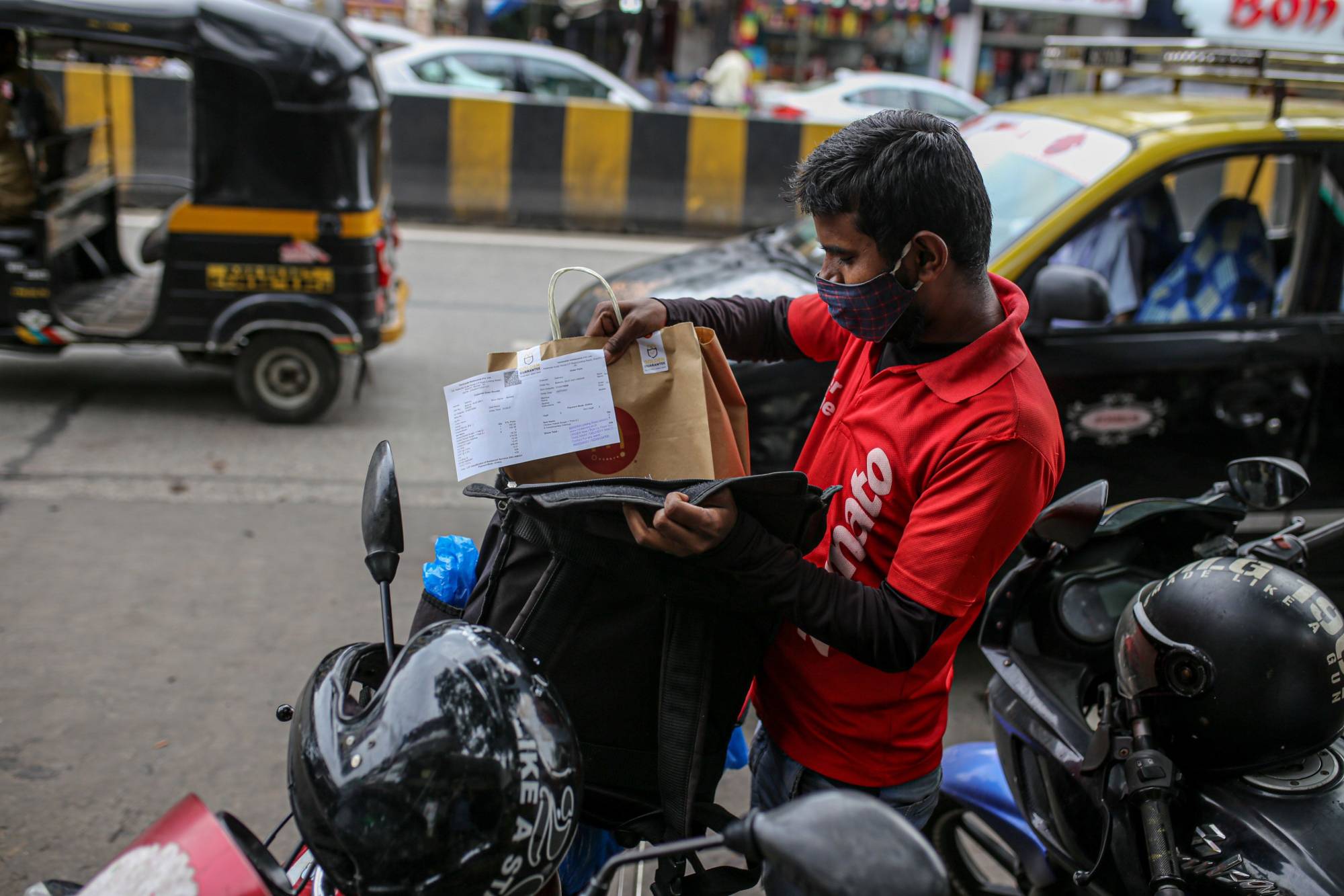 A Zomato delivery worker packs an order into a delivery bag in Mumbai, in July 2021. | Bloomberg