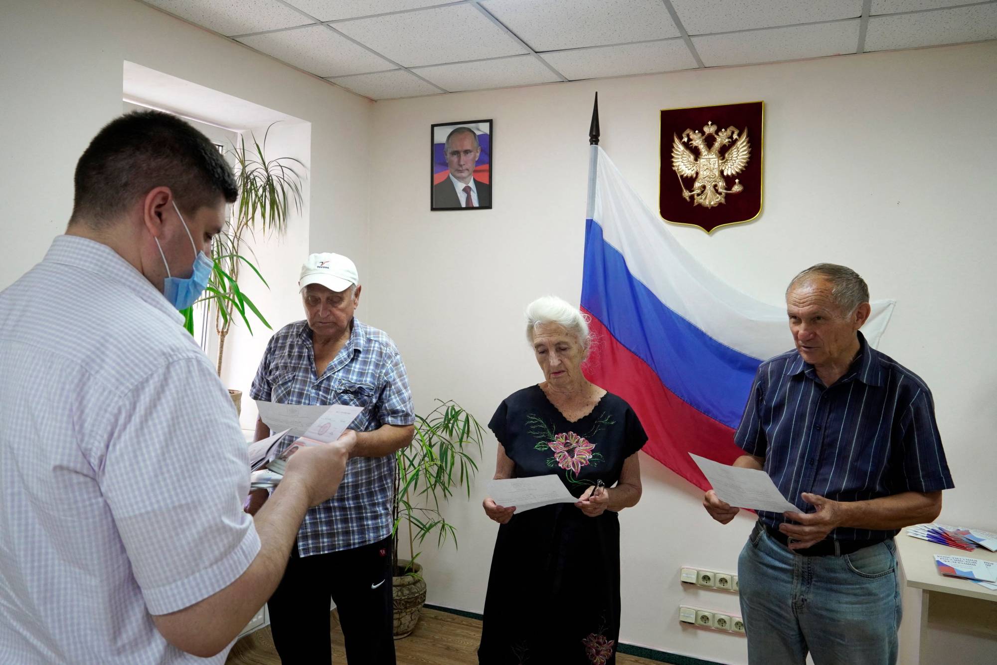 Residents receive Russian passports in Kherson on Thursday, amid the Russian invasion of Ukraine. Russian President Vladimir Putin signed a decree on May 25 simplifying the process for residents of Kherson and Zaporizhzhia to acquire Russian citizenship and passports. | AFP-Jiji