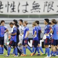 Samurai Blue players leave the pitch after drawing against China in Toyota, Aichi Prefecture, on Sunday. | KYODO
