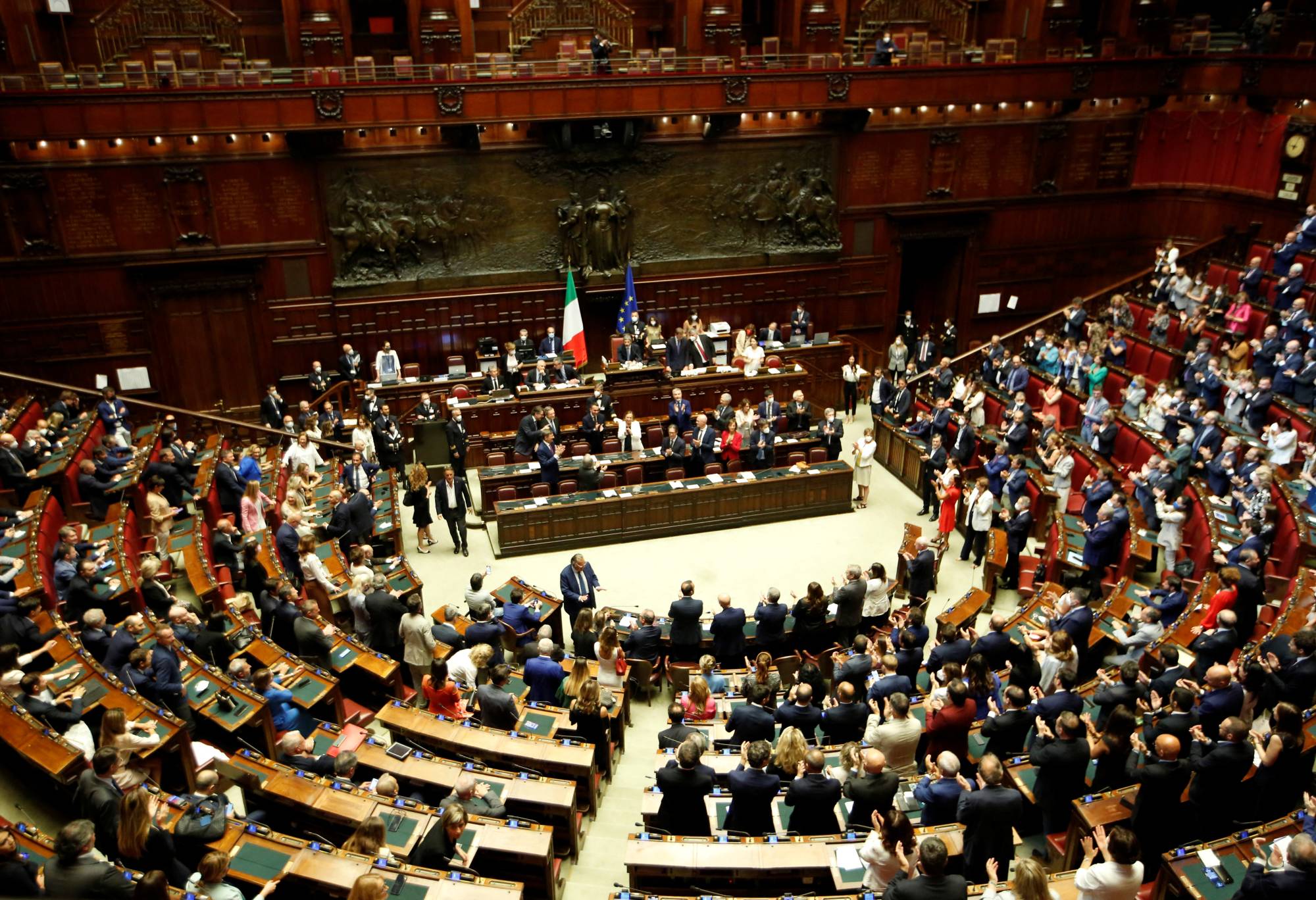 Attendees applaud Italy's Prime Minister Mario Draghi as he arrives to address the lower house of parliament ahead of a vote of confidence for the government after he tendered his resignation last week in the wake of a mutiny by a coalition partner, in Rome, on Thursday. | REUTERS