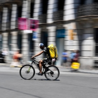 A cyclist working for the food delivery service Glovo rides through Barcelona on July 19. | AFP-JIJI