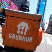 A Grubhub delivery person rides through New York City on May 9. | REUTERS