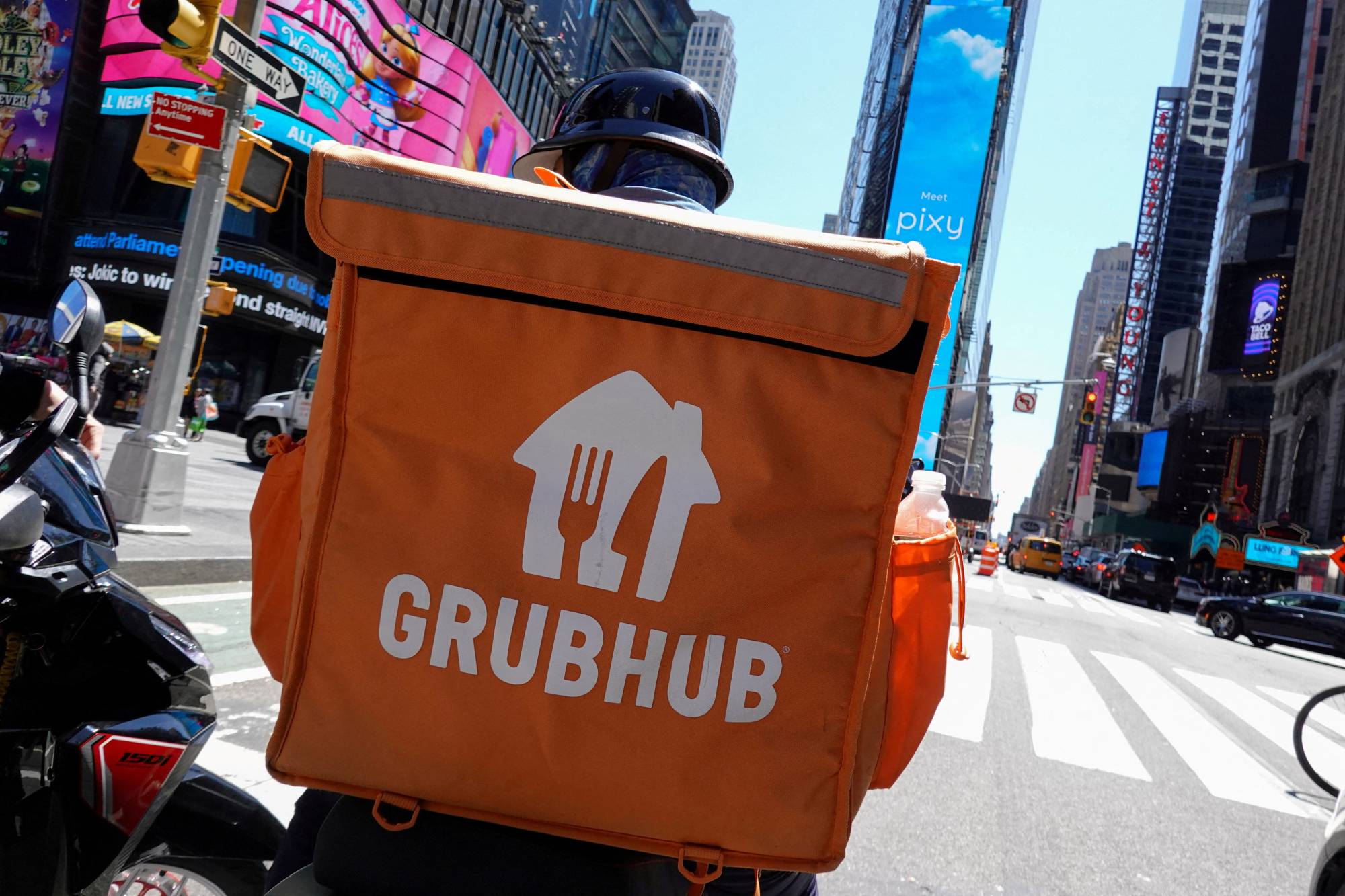 A Grubhub delivery person rides through New York City on May 9. | REUTERS