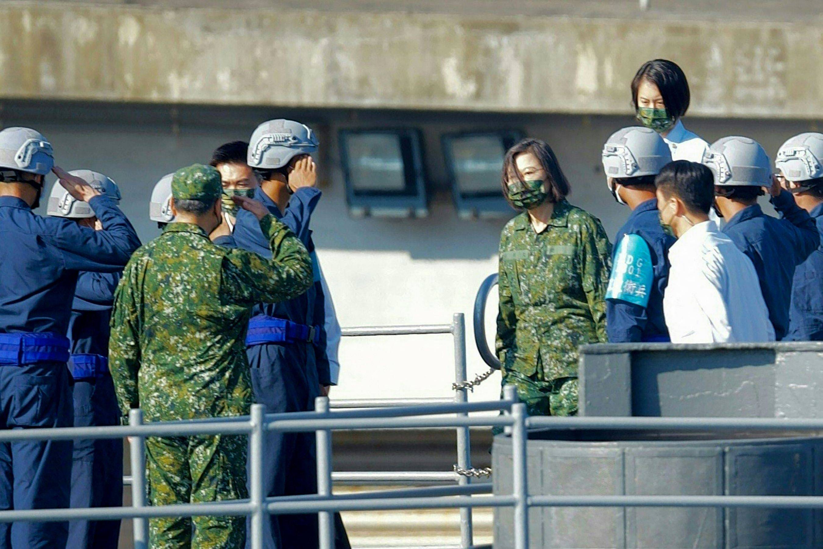 Navy soldiers salute as Taiwan President Tsai Ing-wen (center right) arrives on a destroyer during the annual Han Kuang drill, at the Suao navy harbor in Yilan county on Tuesday. | AFP-JIJI