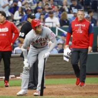 Angels designated hitter Shohei Ohtani holds his right knee after fouling ball off himself during the third inning against the Royals in Kansas City, Missouri, on Monday. | KYODO