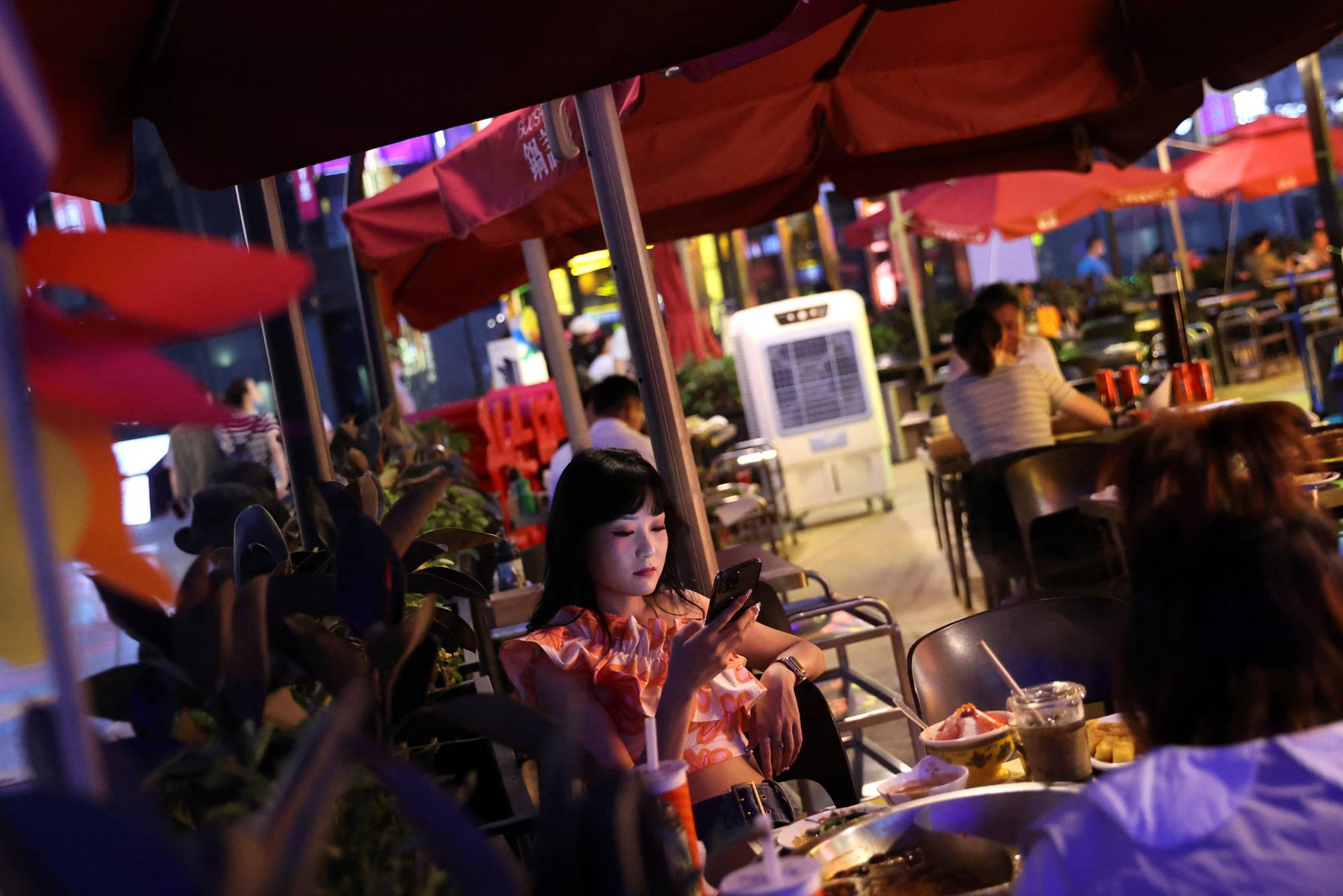 Customers dine at a restaurant at a shopping area in Beijing on Monday. | REUTERS
