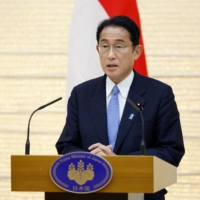 Japan\'s Prime Minister Fumio Kishida speaks during a news conference in Tokyo on Wednesday. Kishida is planning a Middle East trip in late August. | POOL / VIA AFP-JIJI