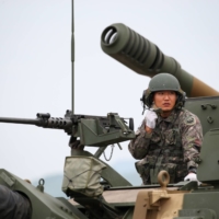 A South Korean soldier sits inside a K9 Thunder self-propelled howitzer at Daegu Air Base in Daegu, South Korea, in September 2019. | BLOOMBERG