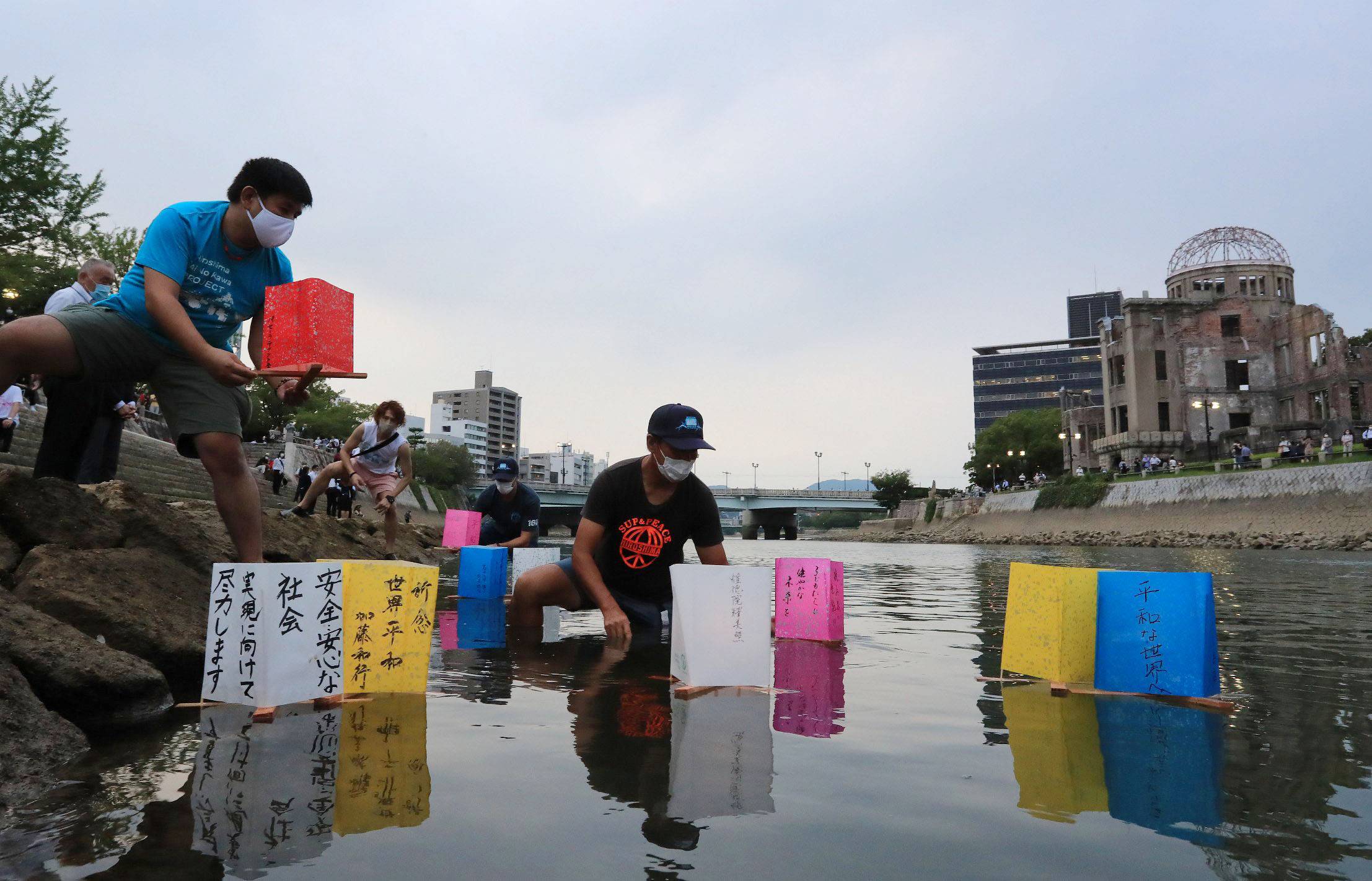People mark the 75th anniversary of the atomic bombing of Hiroshima on Aug. 6, 2020, by releasing paper lanterns on the Motoyasu River facing the Atomic Bomb Dome. | POOL / VIA KYODO