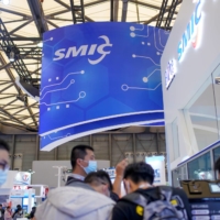 People visit a booth of Semiconductor Manufacturing International Corporation at China International Semiconductor Expo in Shanghai in October 2020. | REUTERS