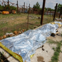 Burnt bodies of detainees are covered following an explosion at a Russian-held detention center in Olenivka, Ukraine, on Friday.   | REUTERS