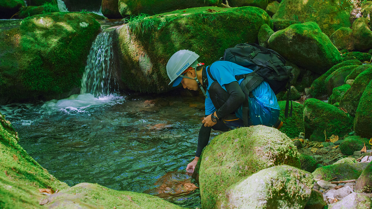 A worker performs a regular water quality check at Suntory’s Okudaisen Natural Water Sanctuary. | © SUNTORY HOLDINGS