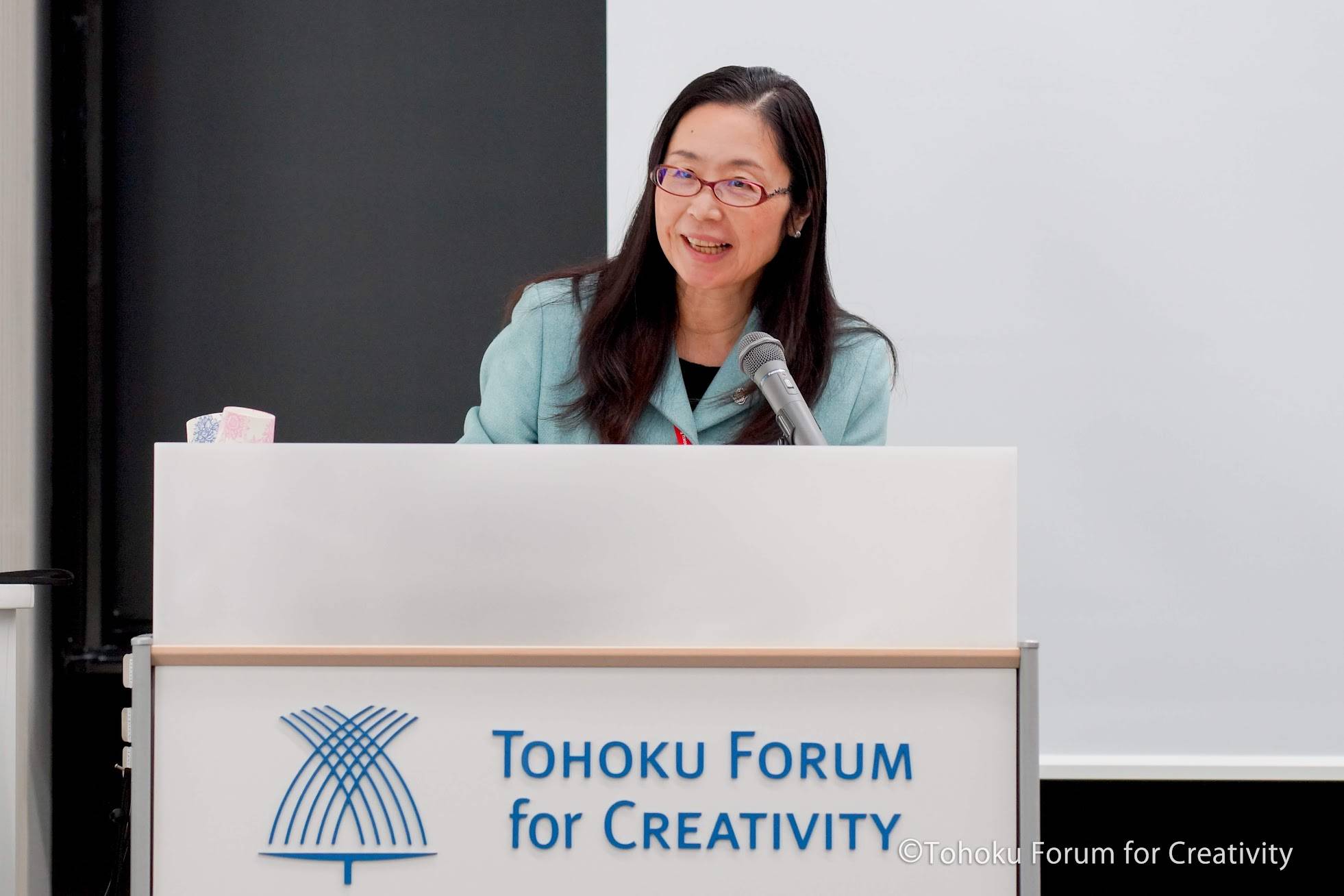 Noriko Osumi delivers the opening remarks at a 2018 science course promotion event for high school girls hosted by the Tohoku Forum for Creativity. Osumi has been instrumental in ensuring girls receive more exposure to role models in the fields of science. | TOHOKU FORUM FOR CREATIVITY