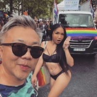 A photo posted on social media by Pavin Chachavalpongpun shows him posing with Aum Neko, who is holding up three fingers in protest against the Thai government, during an event in Paris in late June. | NISHINIPPON SHIMBUN