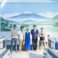 Sam Holden (far left) and Masaya Sammonji (far right) of Sento & Neighborhood pose in one of their renovated urban bathhouses. | COURTESY OF TADA, SENTO & NEIGHBORHOOD
