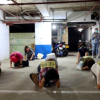 People practice for drill in a basement parking lot that will be used as an air-raid shelter in the event of an attack, in Taipei on July 22. | REUTERS